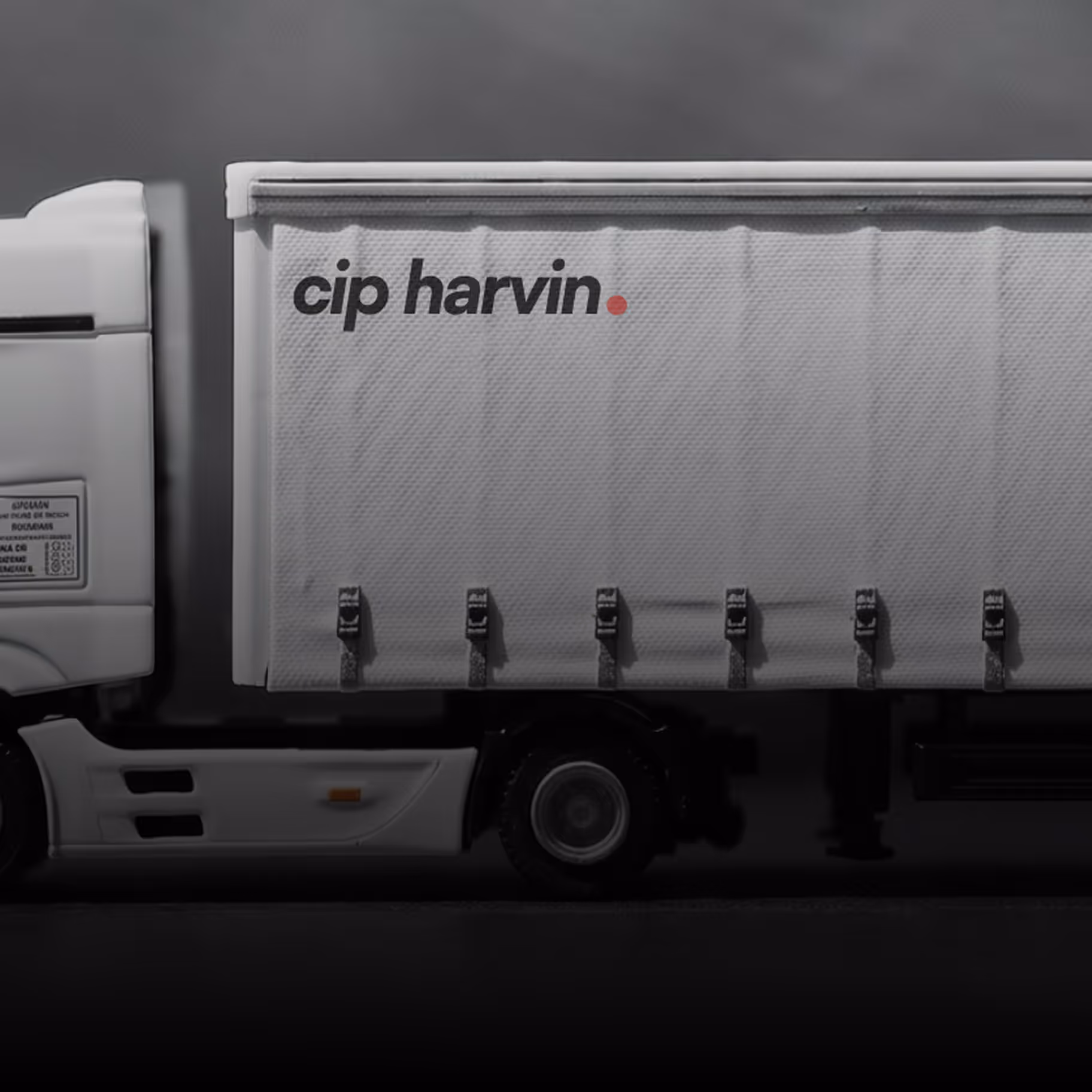 Side view of a white truck trailer with the text 'cip harvin.' on its side.